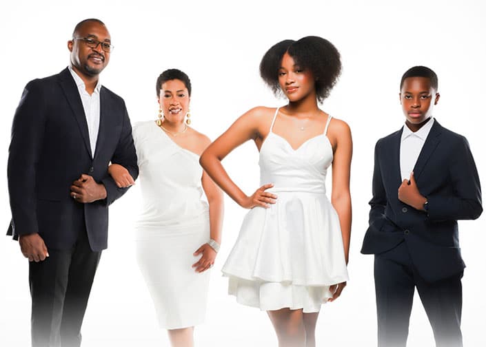 Four people in formal attire posing on a white background.