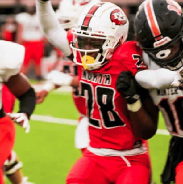 Football players in red uniforms in action on the field.